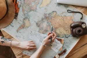 Girl writing on map with camera