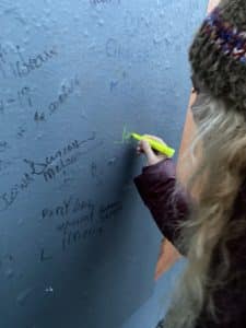 Blonde girl signing Belfast Peace wall